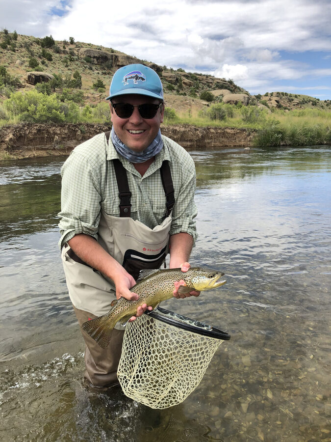 Fly fishing and holding a brown trout on a Montana river